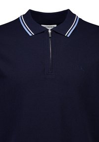 Marinblå pikétröja med halvdragkedja, med en texturerad väv, kontrasterande ljusblå rand på kragen och en subtil logodetalj.