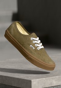 Groene suède sneakers met witte veters, een rubberen tan zool en gestikte details. Beschikt over een klein Vans-logo aan de zijkant.