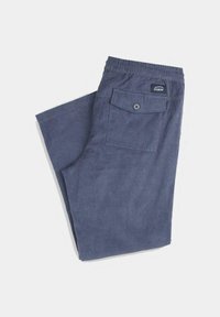 Pantalones de corduroy tejidos en azul oscuro. Presentan un bolsillo trasero con botón y una cintura elástica. Tela texturizada con estrías verticales.