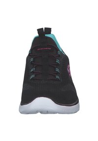 Zapatilla deportiva de malla negra con acentos en rosa y aqua, diseño de cordones elásticos, suela ligera y una lengüeta en el talón para facilitar su uso.
