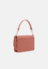 Suorakaiteen muotoinen olkalaukku pehmeää vaaleanpunaista keinonahkaa, jossa on matala muotoilu, kullanväriset ketjusomisteet ja jämäkkä kahva.