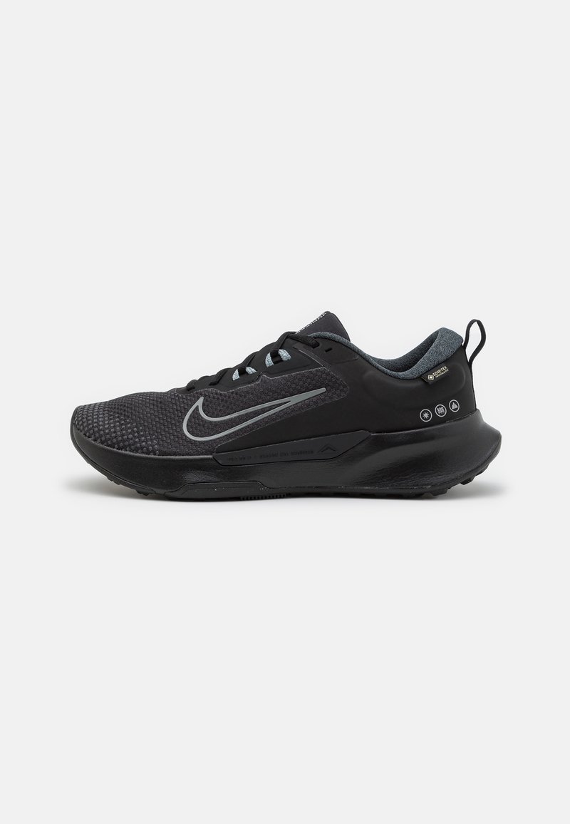 Chaussure de sport noire avec doublure intérieure grise, logo swoosh réfléchissant et étiquette Gore-Tex, montrée de côté gauche sur fond blanc.