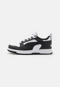Black and white athletic shoes with a leather upper, perforated toe, flat white laces, padded collar, and a logo on the heel.