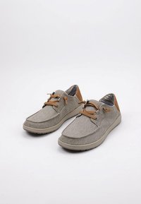 Zapatillas de lona grises con detalles de cuero marrón. Presentan puntera redonda, cordones bicolor y suela de goma texturizada. Diseño casual y ligero.