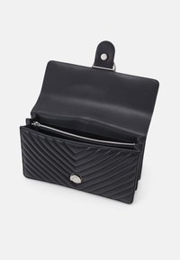Zwarte gewatteerde portemonnee van leer, met een ritszak, drukknoopsluiting en een gladde binnenvoering met een zilveren hardware accent.