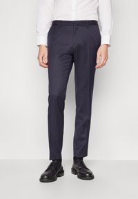 Navy trousers with a tailored fit, made from smooth fabric, featuring flat front, belt loops, and side pockets, paired with black dress shoes.