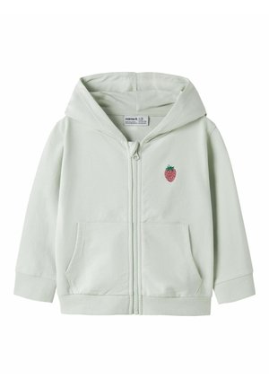 Lysegrøn barnehættetrøje med lynlås foran, kængurulommer og en lille broderet rød jordbær på brystet.