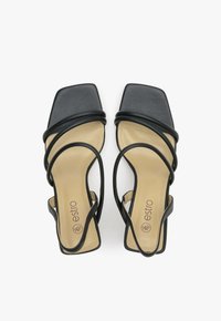 Zwarte vierkante sandalen met meerdere dunne banden en een beige zool. Heeft een gladde leren textuur en minimale branding op de binnenzool.