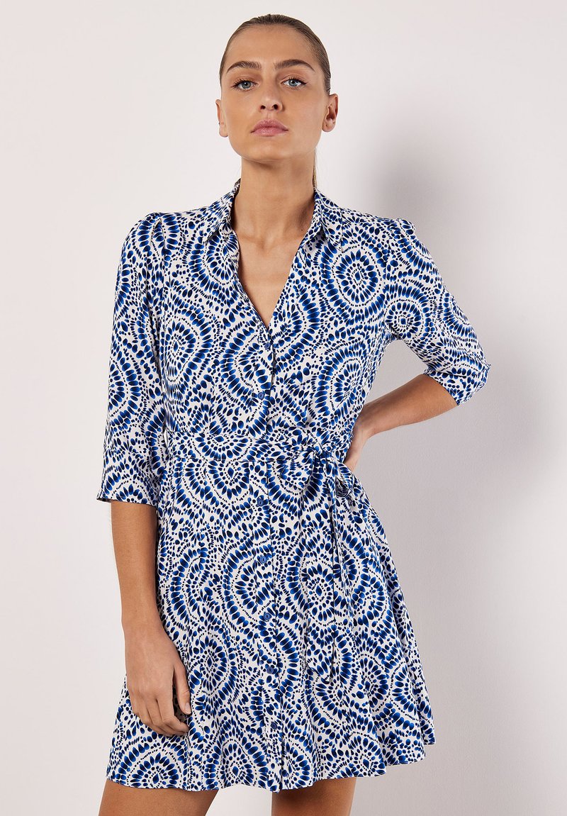 Abito camicia blu e bianco con motivo, colletto, maniche a tre quarti e vita legata, realizzato in un tessuto leggero e con gonna svasata.