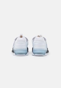 White athletic shoes with a textured upper, black accents, and a translucent blue sole. Features a pull tab on the heel for easy wear.