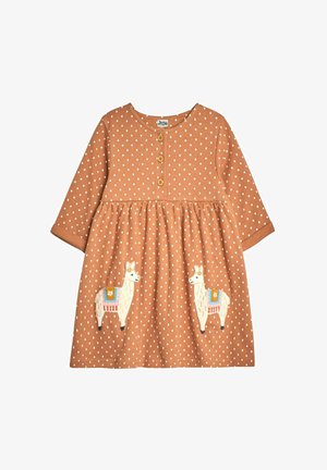 Brązowa sukienka w kropki z długimi rękawami, z trzema drewnianymi guzikami i aplikacjami lamy na spódnicy. Miękka tekstura tkaniny.