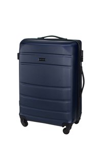 Valigia rigida blu navy con superficie testurizzata, scanalature orizzontali, manico telescopico, quattro ruote e chiusura a zip. Finiture in accento nero.