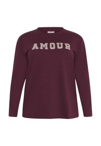 Burgundiški ilgos rankovės džemperis su užrašytu "AMOUR" balta spalva priekyje, turi apvalią iškirptę ir minkštą, tekstūruotą audinį.