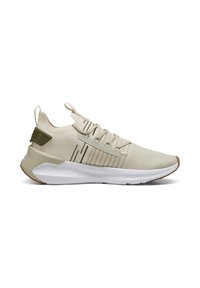 Beige Sport-Schuh aus atmungsaktivem Mesh mit grünen Akzenten, strukturiertem Obermaterial, gepolsterter weißer Sohle und einer Zuglasche an der Rückseite.