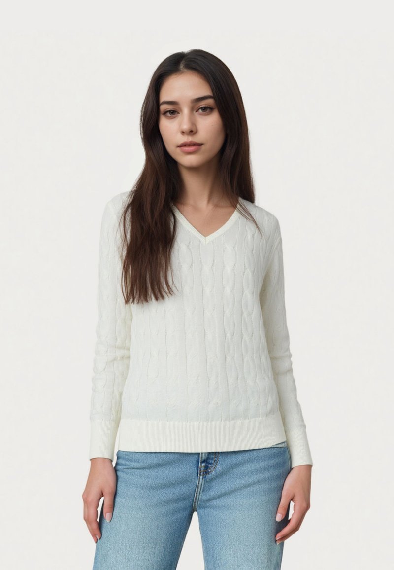 Pulover alb tricotat cu model în relief, cu guler în V, mâneci lungi și tiv cu dungi, asortat cu blugi din denim albastru. Textură moale și design clasic.