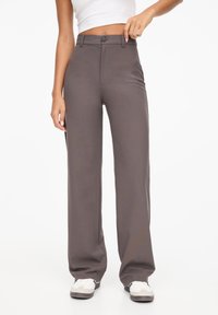 Pantalon gris taille haute à coupe droite, fermeture avant par boutons et passants pour ceinture ; tissu à finition lisse et texturée.