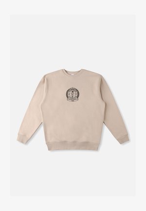 Beiger Pullover mit langen Ärmeln, geripptem Kragen und Saum, mit einem zentralen schwarzen Emblem mit Lorbeer-Details. Glatte Baumwolltextur.