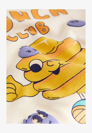 Personaj de brânză desen animat, cu ochi mari și limbă scoasă, înconjurat de fructe de pădure violete zâmbitoare, pe o țesătură albă texturată.