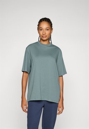 T-shirt a maniche corte, dalla vestibilità ampia, in cotone teal tenue, con scollatura rotonda e minimal branding sul petto.