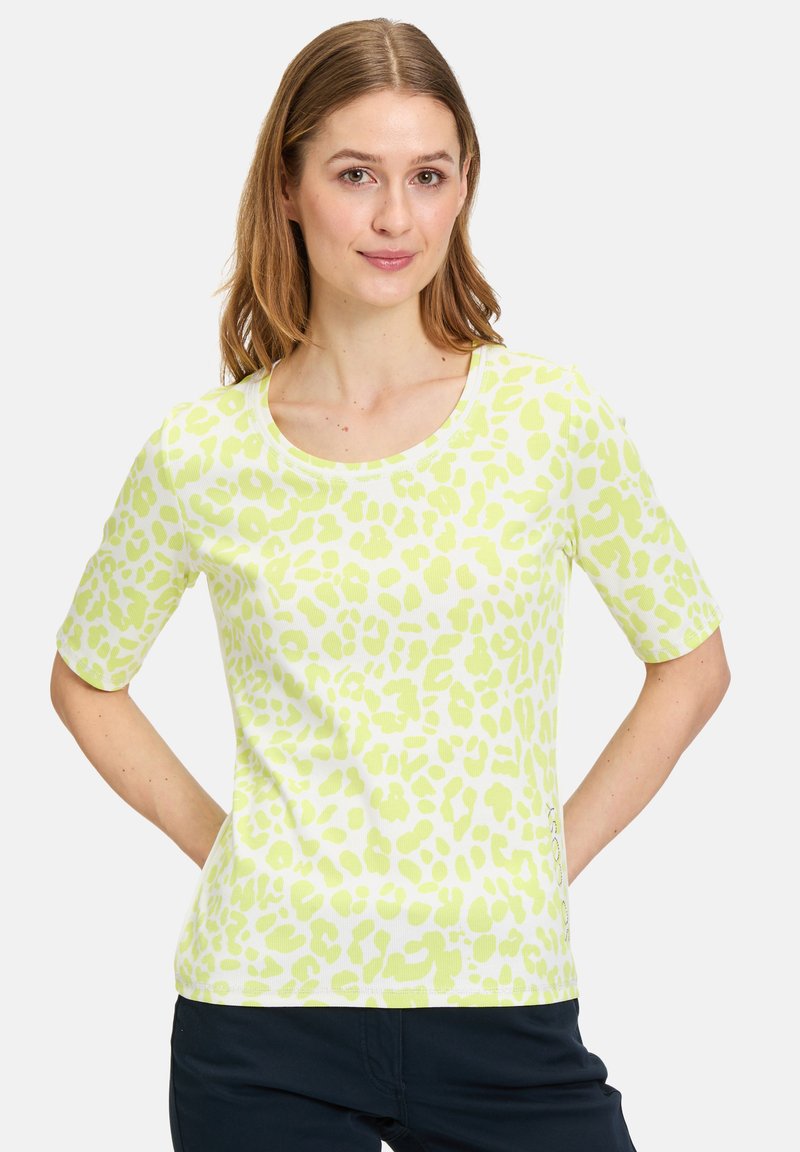 Grøn og hvid t-shirt med korte ærmer, der har et leopardprint mønster, rund halsudskæring og tekstureret stof. Løs pasform.