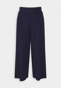 Pantalons larges bleu marine avec une texture côtelée, dotés d'une taille élastique et d'une coupe ample, conçus pour le confort et la liberté de mouvement.