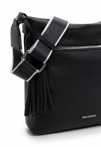 Sort læder crossbody taske med sølvhardware, struktureret overflade, justerbar rem og dekorative frynser. Har en lynlåslomme.