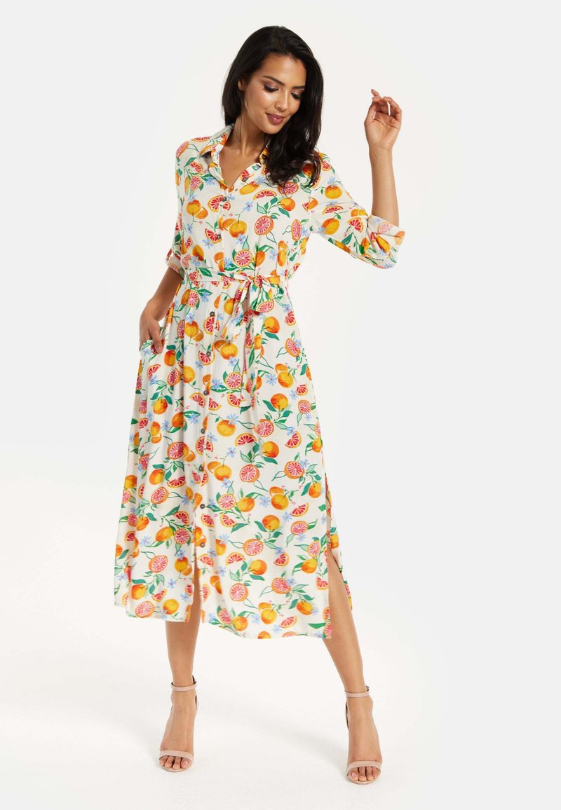 Floral dress in lightweight fabric, featuring orange and floral patterns, collar, and waist tie. Length extends to mid-calf with side slits.