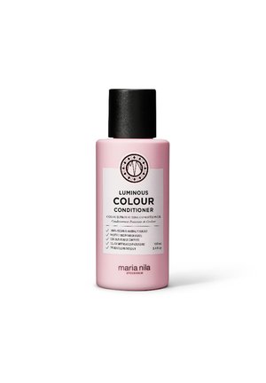 Luminous Colour Conditioner in een roze fles met een zwarte dop. Heeft een wit etiket met tekst en een cirkelvormig logo, capaciteit van 100 ml.