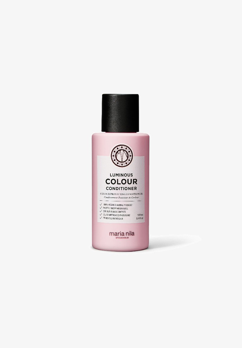 Luminous Colour Conditioner in een roze fles met een zwarte dop. Heeft een wit etiket met tekst en een cirkelvormig logo, capaciteit van 100 ml.