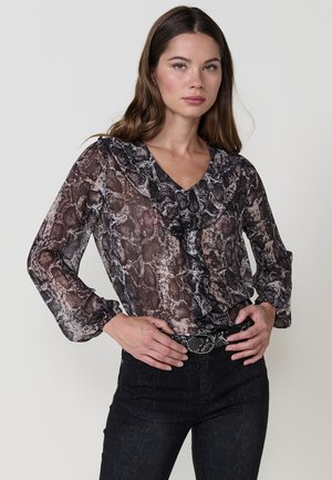 Blusa transparente de manga larga con un estampado de serpiente en tonos de negro y beige. Presenta un escote en v con volantes y mangas abullonadas.