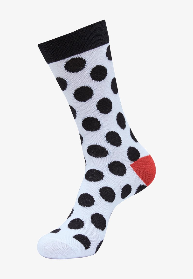 Sort og hvid prikket strømpe med en rød hæl. Strømperne har en glat tekstur og en ribbet sort manchet foroven.