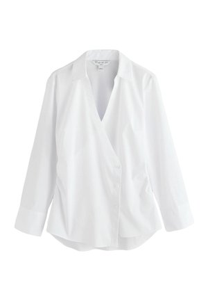 Balti marškiniai mygtukais, V formos iškirpte, ilgomis rankovėmis ir išlenktu apačios kraštu. Pagaminti iš lygaus audinio, turi klasikinį apykaklę ir užsegimą priekyje su mygtukais.