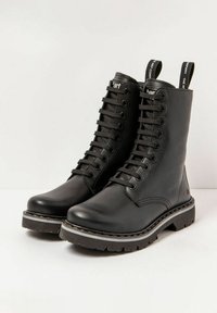 Bottes en cuir noir à lacets, hauteur cheville, semelle robuste et accents de couture contrastants. Présente une languette à l'arrière.