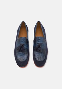 Mocasines de ante marino con textura de cocodrilo en relieve y detalle de borlas. Interior de cuero suave y suela de color contrastante.