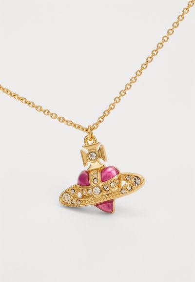 Collana d'oro con pendente a forma di cuore rosa, circondato da scintillanti pietre trasparenti, decorata con un fiocco nella parte superiore e un design intricato.
