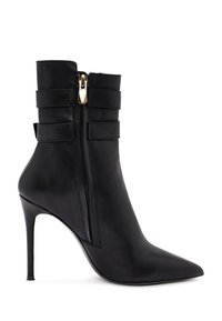Botte cheville en cuir noir avec bout pointu, talon stiletto haut, fermeture éclair latérale et deux sangles décoratives horizontales autour de la cheville.