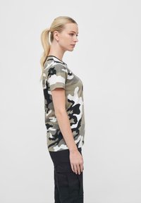 Camo-mønsteret kortermet t-skjorte i grønn, beige og svart. Laget av bomull med rund hals og avslappet passform.