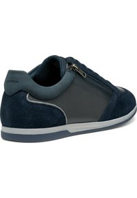 Baskets bleu marine ensuivant un mélange de daim et de cuir lisse, avec une fermeture éclair et une semelle en caoutchouc blanche avec un accent gris texturé.