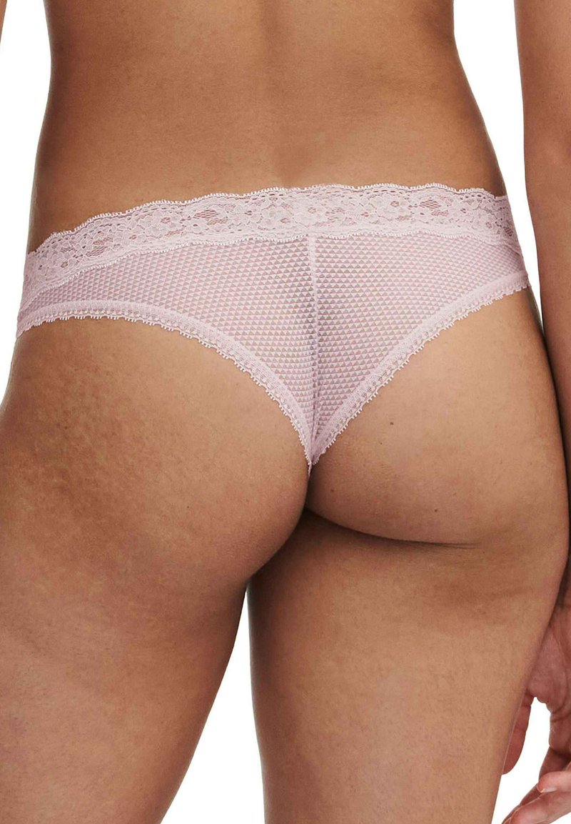 Lencería rosa con detalles de encaje, que presenta un diseño de malla texturizada y un patrón geométrico, con bordes ondulados a lo largo de la cinturilla.