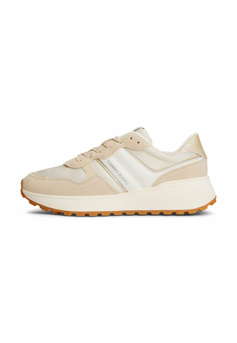 Sneakers atletiche beige con tomaia in suede e mesh, caratterizzati da una striscia laterale bianca e una suola in gomma di colore caramello.