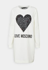Bílé šaty se dlouhými rukávy v oversize střihu, které zdobí velké černé srdce složené z menších barevných srdcí a text "LOVE MOSCHINO" pod ním.