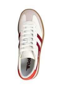 Zapatilla deportiva blanca con rayas rojas a los lados, suela de goma, cordones blancos y acento naranja en el talón, mostrada desde arriba.