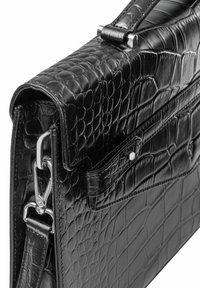 Czarna skórzana torba na ramię o strukturze krokodyla, z srebrnymi akcentami i odpinanym paskiem. Posiada zapięcie na klapkę oraz zewnętrzną kieszeń.