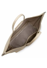 Sac fourre-tout beige avec une surface lisse, deux poignées, un intérieur spacieux et une poche zippée. L'intérieur est doté d'une doublure subtile.