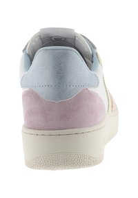 Zapatilla blanca con paneles de ante azul claro y rosa en el talón, suela texturizada beige y lengüeta visible dentro del cuello.