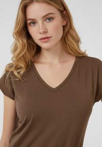 Brun V-ringad t-shirt i mjukt tyg med korta ärmar. Slät textur och enkel design med en ren halsringning.