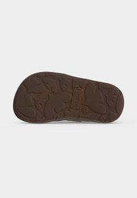 Semelle d'une chaussure marron avec un motif de feuille et le nom de la marque "bisgaard" embossé au centre.