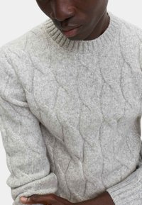 Grauer, gestrickter Pullover mit rundem Ausschnitt, strukturiertem Muster und gerippten Bündchen. Der Stoff wirkt weich und warm, ideal für kühleres Wetter.