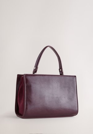 Bordeauxfarvet håndtaske lavet af kunstlæder med en glat, blank finish. Har to korte håndtag og en struktureret, rektangulær form.