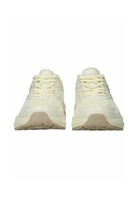 Pari kermanvärisiä Blackstone-tennareita, joissa verkkokangasta ja nahkaisia yksityiskohtia, etunäkymä jossa näkyy nauhat ja kuvioidut pohjat.